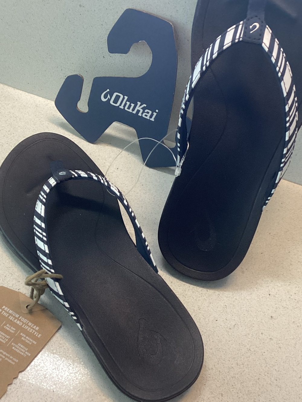 OluKai Black Flip Flops with White Striped Straps